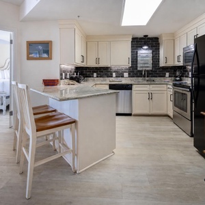 Enjoy cooking in the stylish kitchen with stainless and black appliances and a convenient breakfast bar