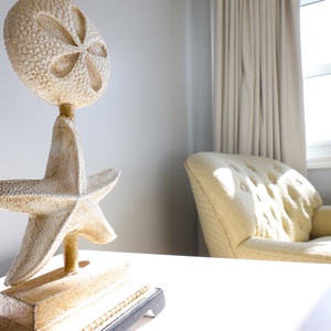 The corner features a decorative starfish sculpture and a cozy yellow armchair, perfect for relaxation and beach vibes