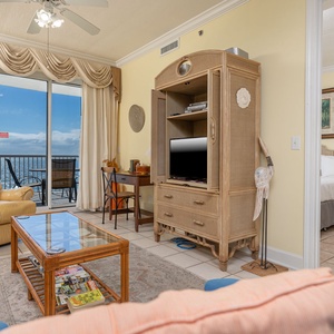 This cozy living area features a TV, inviting seating, and a stunning beachfront view through large sliding glass doors