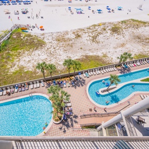 Enjoy a vibrant pool and lazy river area with lush palm trees and easy beach access, perfect for relaxing and fun in the sun