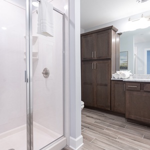 Refresh in this guest bath with a glass walk-in shower, rich cabinetry, and stylish countertops
