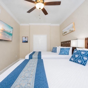 Two queen beds in the guest suite welcome restful nights surrounded by coastal-inspired artwork and soft lighting