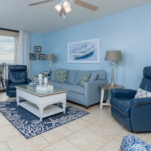 Relax in the inviting living area, featuring a queen sleeper sofa and coastal decor with a beachfront view