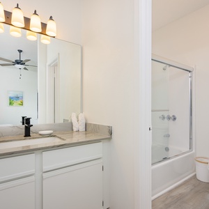 Refreshing guest bathroom featuring a sleek vanity, modern fixtures, and a relaxing tub/shower combo for your comfort