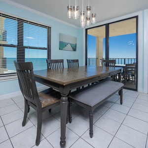 Dining area with a wooden table, modern decor, and breathtaking views of the tranquil waters beyond the glass doors