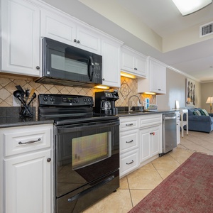 Black appliances complement white cabinetry as you prepare meals and catch a show in the living room