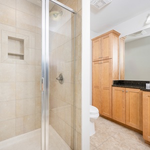 Refresh in the stylish guest bathroom featuring a walk-in shower, sleek cabinetry, and ample counter space