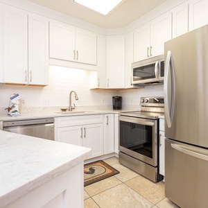 Cook and gather in this bright kitchen featuring stainless steel appliances, ample counter space, and colorful decor