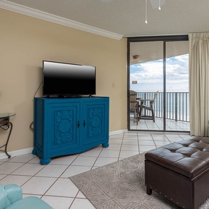 Relax in the inviting living area, featuring a TV, sofa with queen sleeper, and views of the beach balcony