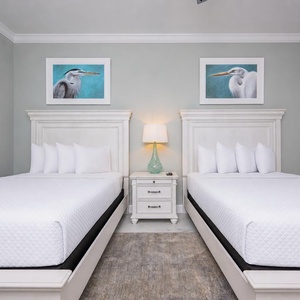 Rest peacefully in this tranquil guest room featuring two queen beds, soft lighting, and a coastal vibe