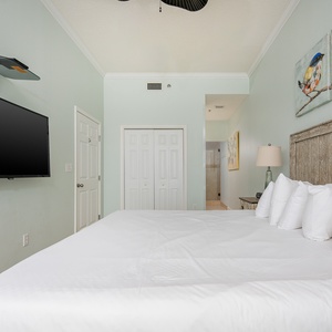 Brightly colored art complements the inviting king bed in the master, while a TV and soft lighting enhance the relaxing vibe