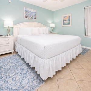 Brightly colored walls complement the inviting king bed, while decorative artwork adds a touch of charm to the cozy retreat