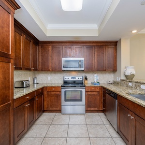 Prepare meals in this stylish kitchen, featuring rich wood cabinetry and stainless appliances