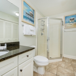 Additional bath featuring a walk-in shower, granite countertops, laundry area with washer/dryer, and relaxing beach art