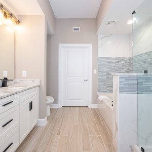 Refresh in this modern master bath featuring elegant tile, a refreshing tub, and walk-in shower
