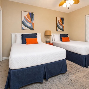 Relax in this cheerful guest bedroom featuring two twin beds, colorful accents, and a cozy atmosphere for restful nights