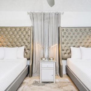 Elegant bedroom with two queen beds, stylish headboards, and modern bedside lamps for a cozy retreat