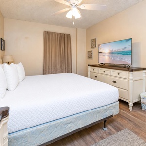 The master bedroom features a plush white bed, soft lighting, and warm beige tones for a restful retreat