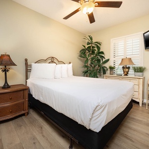 Rest in this guest bedroom featuring a comfortable queen bed, tasteful decor, and a TV for your entertainment