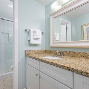 Bright and airy master bath featuring a spacious vanity with granite countertops and decorative accents