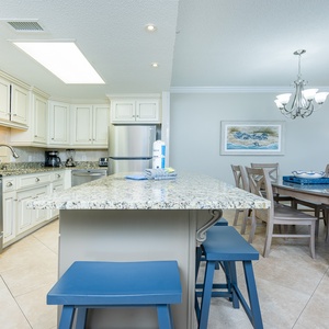 Enjoy meals at the granite island or dining table, surrounded by light and inviting decor in this spacious kitchen area