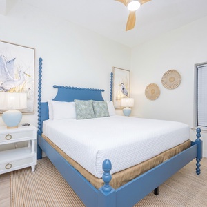 Relax in the inviting bedroom featuring a king bed, stylish decor, and a mounted TV for your entertainment