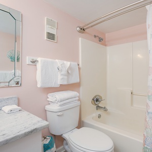 Indulge in a refreshing wash in this master bath, where plush towels await your beach adventures