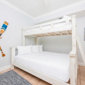 Charming bunk room with cheerful decor and a twin over queen bunk