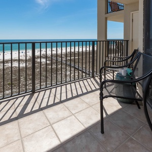 Balcony seating offers a serene view of the beach and turquoise waters, perfect for morning coffee or evening sunsets