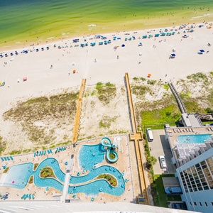 Discover the inviting pool area with gradual entry, a refreshing lazy river, and fun waterslide on the beach