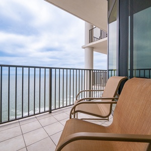 Relax on the balcony with comfortable seating and views of the tranquil waters and gentle waves