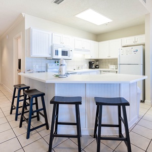 Gather around the inviting kitchen with bar stools, perfect for casual meals or coffee and conversations