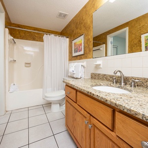 Refresh in this guest bath featuring a granite countertop, spacious vanity, and a tub-shower combination
