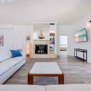 Inviting living room featuring a cozy fireplace, large TV, and stylish decor, perfect for relaxation and entertainment