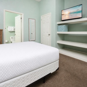 Enjoy the calming beach vibe and watching your favorite shows on the mounted TV in this guest room with full beds