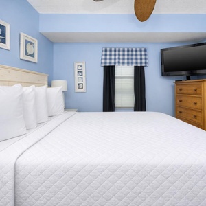 Relax in this inviting bedroom featuring a plush bed, cozy decor, and a TV for entertainment