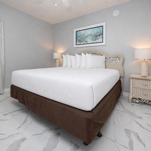 Unwind in the serene bedroom featuring a plush king bed, stylish decor, and soft lighting for a restful retreat