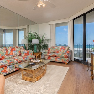 Colorful floral sofas with a queen sleeper create a tropical vibe in this inviting living area with stunning gulf views