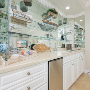 Experience delightful moments preparing your favorite drinks at the stylish wet bar with coastal decor