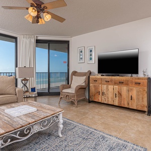 Relax in the inviting living area with plush seating, a rustic coffee table, and beach views through large windows
