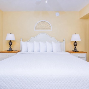 Inviting king bed, flanked by stylish lamps and a framed artwork, creating a cozy retreat