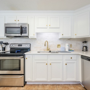 Prepare meals in this stylish kitchen featuring stainless steel appliances and elegant cabinetry for your culinary adventures