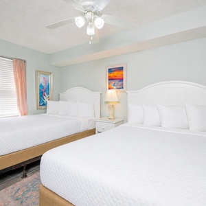 Two double beds in the guest suite invite you to lounge and dream under the rhythmic hum of the ceiling fan