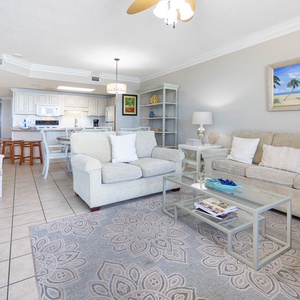 Inviting living area featuring a sofa with queen sleeper, a stylish coffee table, and a view of the open kitchen