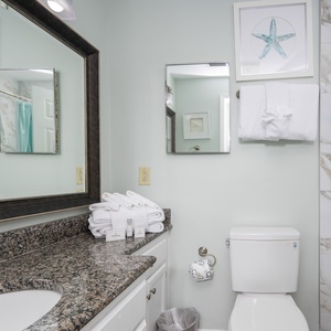 The guest bath features elegant marble accents, a spacious vanity with granite countertops, and a relaxing tub/shower combo