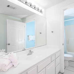 This bathroom features a bright, clean design with white cabinetry, a spacious vanity, and fresh towels for your comfort
