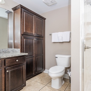 Enjoy a relaxing shower after a day at the beach in this guest bath with stylish cabinetry and spacious vanity