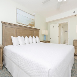 Inviting room featuring a plush king bed, stylish blue lamp, and adjoining bathroom