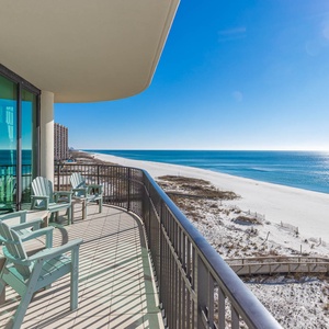 Adirondack chairs soaking in the expansive views of the beach and calm waters