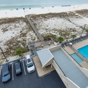 Enjoy the serene beach access and inviting pool area from this elevated view of your vacation retreat